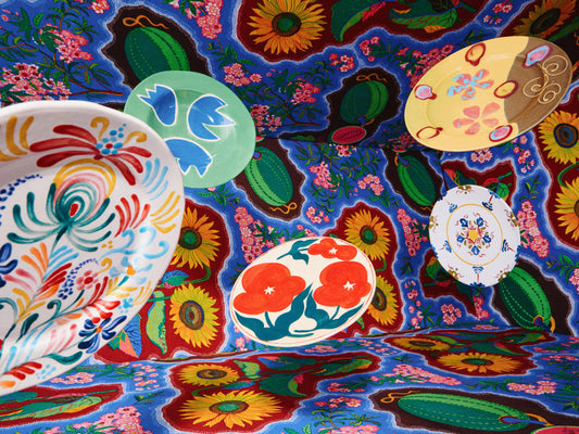 Decorative floral ceramic plates and patterned tableware styled on a linen tablecloth