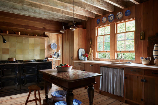 Layered interior with vintage and contemporary furniture mixed together, warm natural materials and soft autumn light