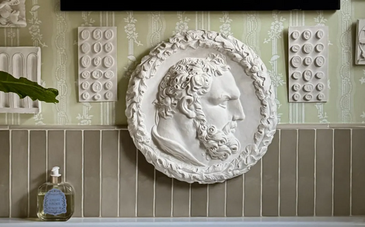 Contemporary interior with classical Greek design references including sculptural objects, limewashed walls and natural stone materials